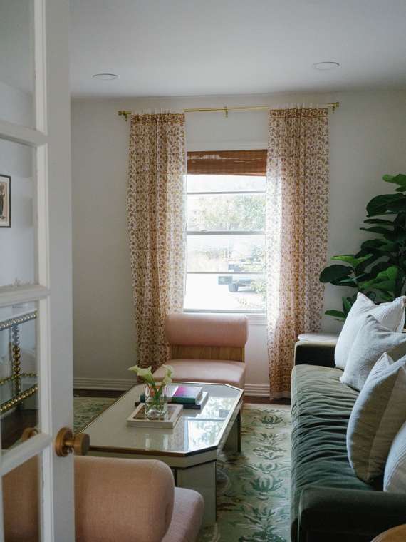 The Lounge, with blush chairs, a velvet sofa and floral curtains
